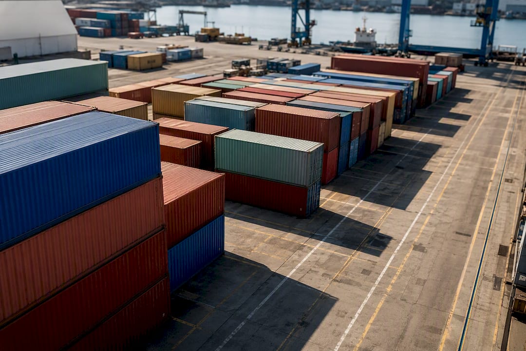 Stacked shipping containers in busy port
